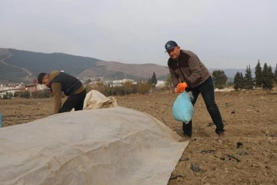 Depremzede çiftçi kışın da üretime devam etmek için tarlasına sera kuruyor